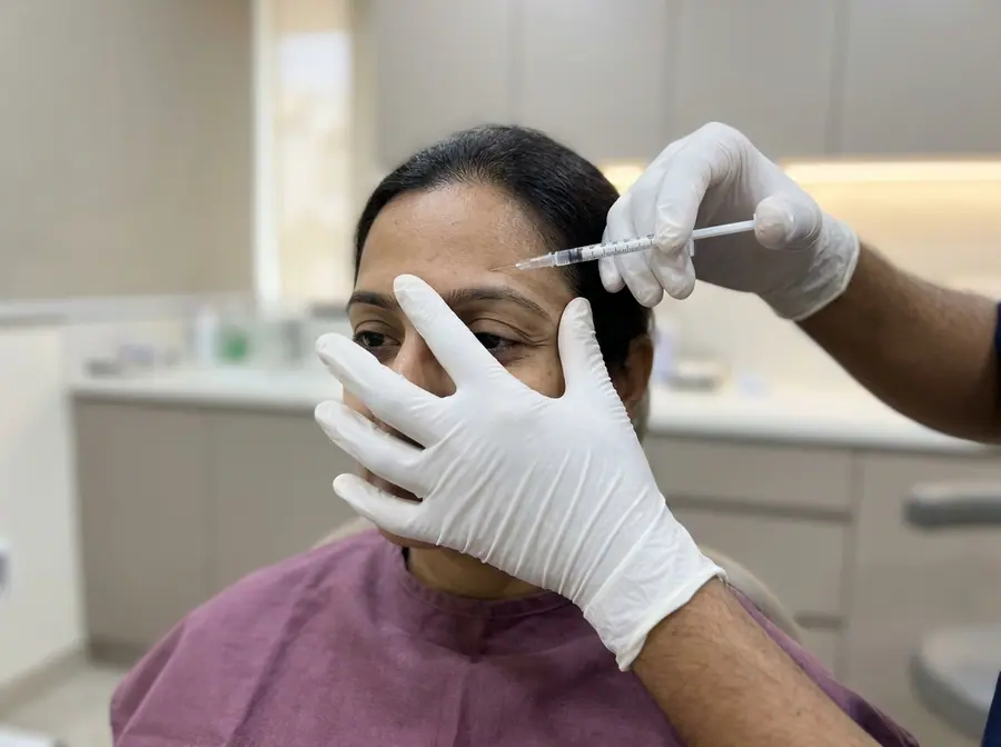 A gloved doctor giving a small injection to a woman's forehead (illustrative photo)