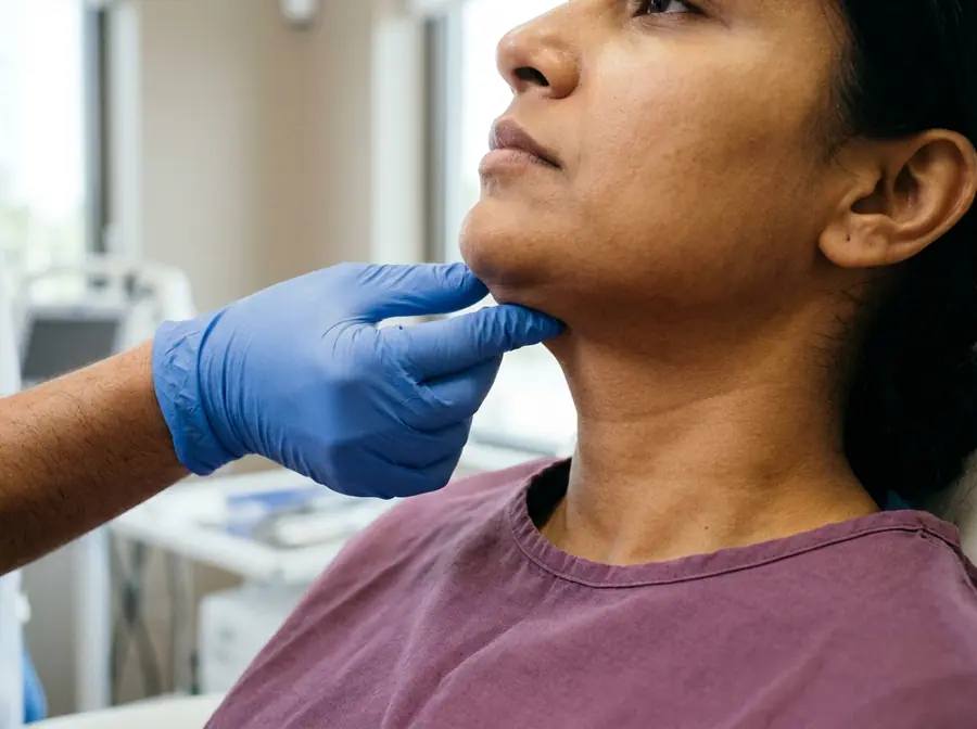 A doctor feeling the fat under a woman's chin and jaw (illustrative photo)