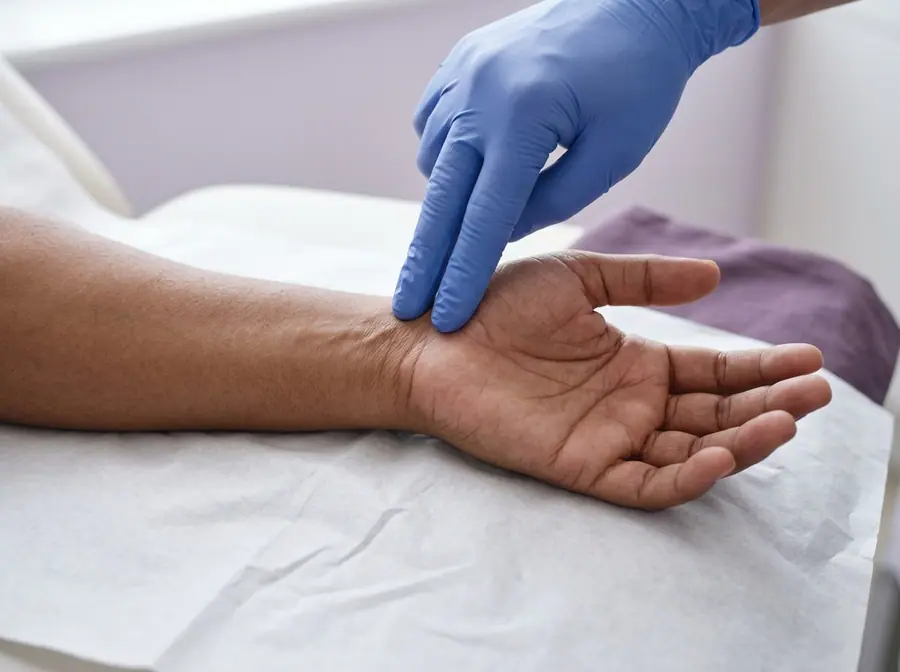 A doctor pressing over the wrist crease to check for carpal tunnel syndrome (illustrative photo)
